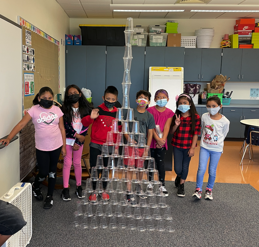 students posing behind their tower of stacked plastic cups